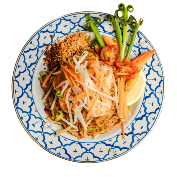 Prawn pad thai on a blue and white Thai plate with peanuts and lime.